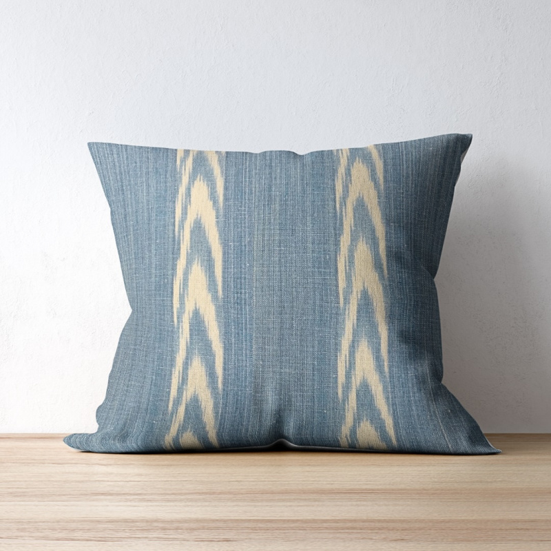 Alcadena Sky Blue fabric by Teixits Riera on a throw pillow